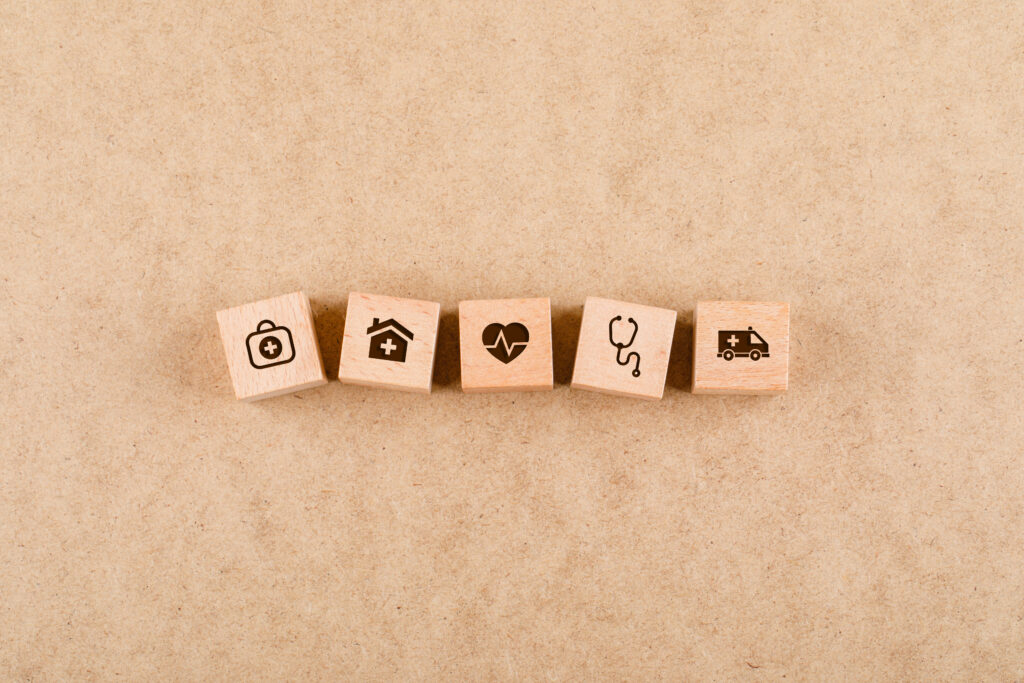 Medical check up concept with wooden blocks with medical icons on cardboard background flat lay. free space for your text. horizontal image